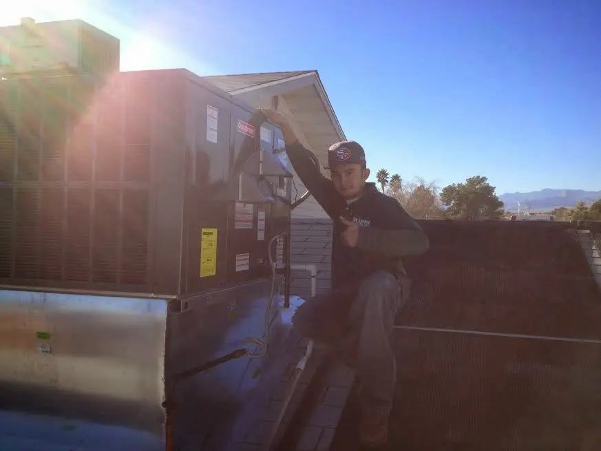 HVAC technician performing AC Tune-Up on a rooftop unit in Pea Ridge